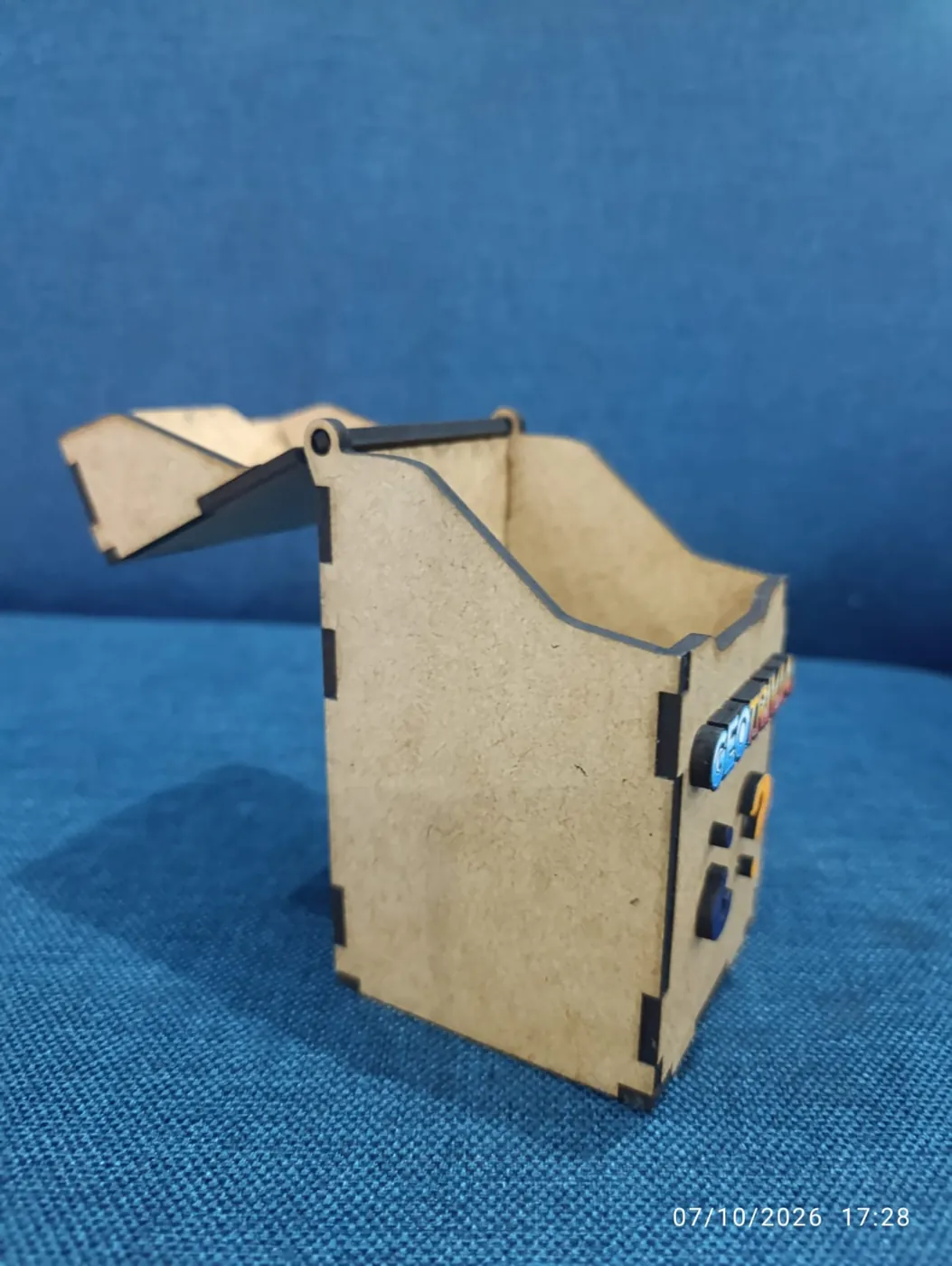 Caja de MDF con tapa articulada por una varilla metálica y el perfil lateral curvo